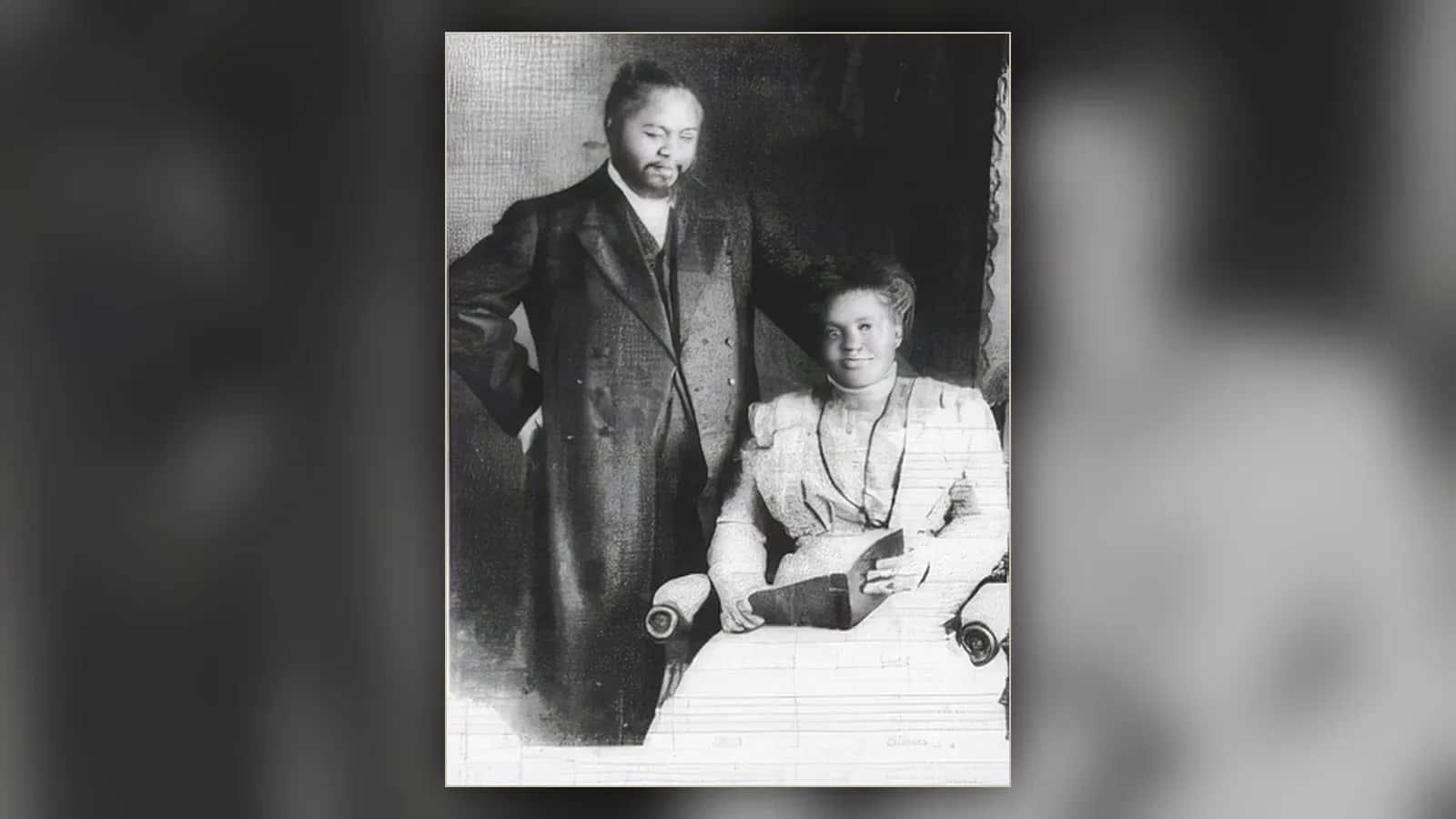 Archiwalne zdjęcie: William Seymour stoi z ręką w kieszeni, Jennie Evans Moore siedzi obok z książką na kolanach