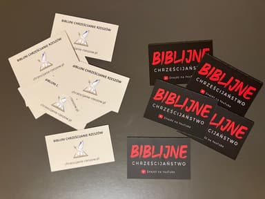 Wizytówki „Biblijni Chrześcijanie Rzeszów” i naklejki „Biblijne chrześcijaństwo” leżące na stole
